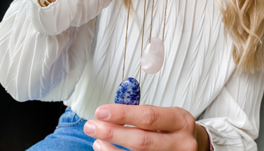 femme qui tient un collier en pierre naturelle bleu